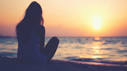 Fototapeta premium Silhouette of a Woman Contemplating the Sunset at the Beach