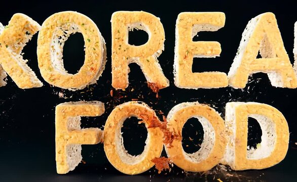 The words "KOREAN FOOD" are spelled out in a 3D animation using bread slices. The letters are tumbling into place, and there is a light dusting of spices around them.