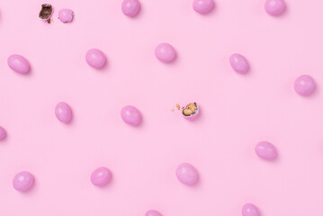 Pink easter dragee on a pink background. Sweet candies in the shape of eggs covered with pink glaze
