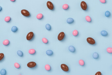 Blue easter dragee on a blue background. Sweet candies in the shape of eggs covered with blue glaze