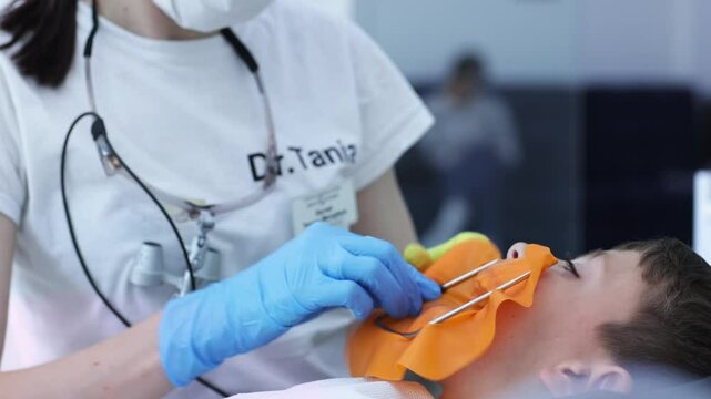 Process of installing a dental cofferdam for dental treatment on child.