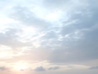 Obraz premium Sky at Sunset: A captivating skyscape, painted with hues of golden yellow, pink, and soft blue, showcasing delicate clouds illuminated by the setting sun.