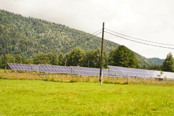 Solar panels in green countryside with mountain view