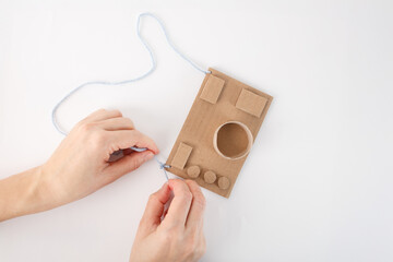 step in creative process of assembling a toy camera from cardboard with colorful details. a pair of...