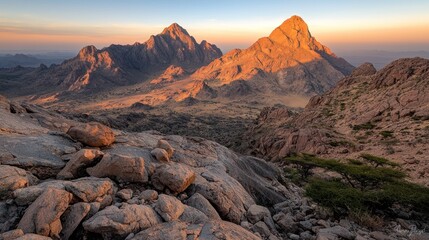Obraz premium Sunset over desert mountains, rocky foreground