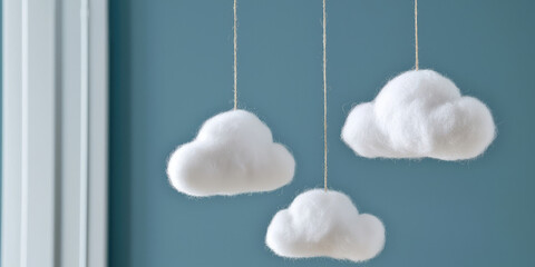 Clouds made of absorbent cotton hang from strings from the ceiling. Handmade Interior decoration.