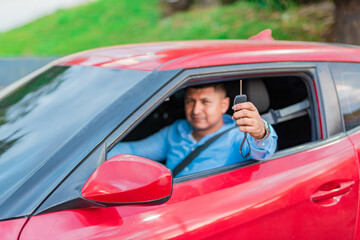 Happy driver showing car key. Male driver showing his car keys