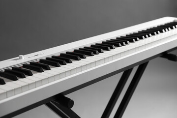 Synthesizer on grey background, closeup. Electronic musical instrument