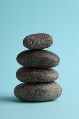 Stack of rocks on light blue background. Harmony and life balance