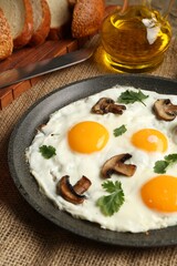 Tasty fried eggs with mushrooms and parsley served on table, closeup