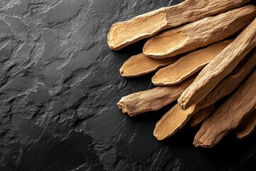 Dried ashwagandha root slices on black slate background