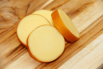 SMOKED PROVOLONE CHEESE ON A WOODEN BOARD