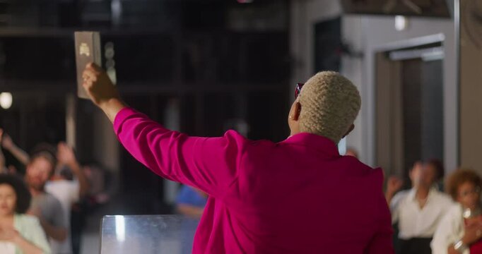 Close-up of preacher addressing congregation, vibrant energy with raised hand, indoor church setting, spiritual connection and group worship, dynamic leadership in prayer