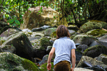 Child Walking Through a Mossy Rainforest
