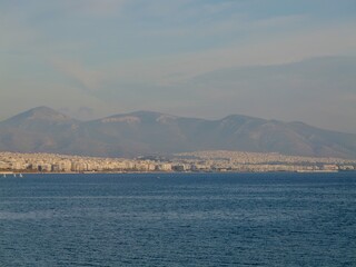 Fototapeta premium View of the seaside and Hymettus or Hymettos, a mountain range in the Athens area of Attica, from the Votsalakia beach, Piraeus, Greece
