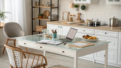 A bright kitchen workspace with a laptop, notebook, and fruit bowl on a white table