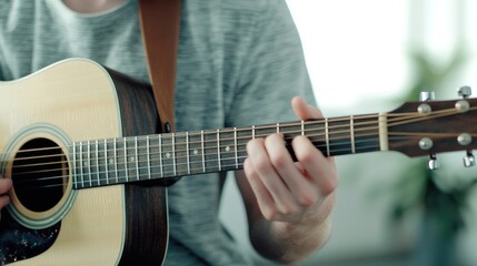 Fototapeta premium A person playing an acoustic guitar, showcasing finger positioning and technique, set in a bright, modern environment.