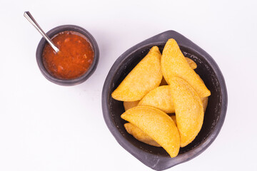 Colombian empanada with spicy sauce 
