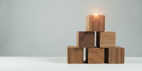 Wooden blocks arranged in an ascending structure, symbolizing growth, progress, and achievement.  The top block glows, representing success and potential.