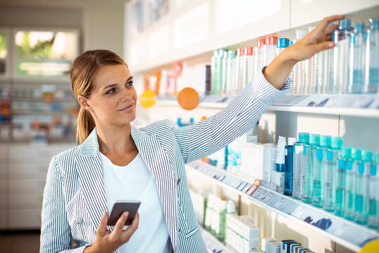 Woman shopping for skincare products in pharmacy aisle
