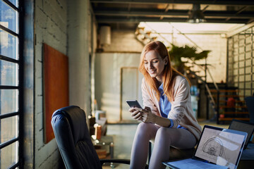 Young woman working in the office and using a smart phone