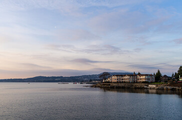 Fototapeta premium Seaside Buildings with Mountainous Horizon at Serene Dusk Light