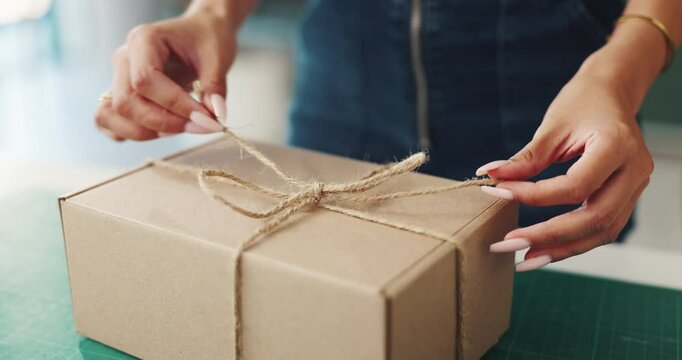 Woman, wrapping or hands with box for present, small business or packaging order at warehouse. Delivery, strings tie and owner with parcel, gift or product for shipping, closeup or courier service
