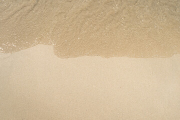 Summer waves crash on the sandy beach