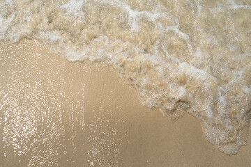 Summer waves crash on the sandy beach