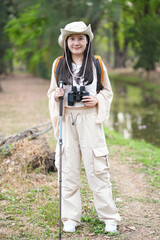 portrait young female tourist with hiking equipment standing in the national forest park,posing to camera.