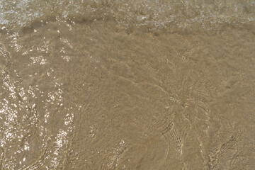 Summer waves crash on the sandy beach