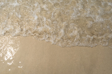 Summer waves crash on the sandy beach