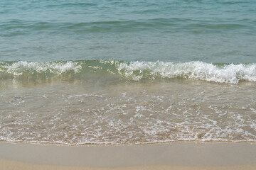 Summer waves crash on the sandy beach