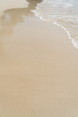Summer waves crash on the sandy beach