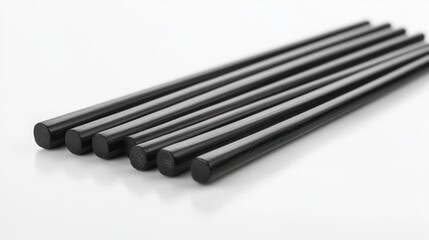 Black glue sticks arranged on white surface