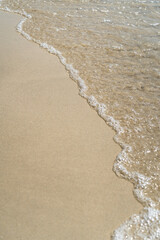 Summer waves crash on the sandy beach