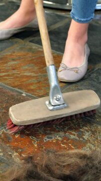 Hairdresser cleaning the waste on floor