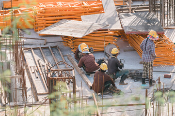Construction Workers in Action, Group of construction workers diligently lay out materials at...