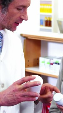 Pharmacist assisting the bottle of drug to customer