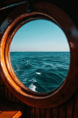 Fototapeta premium Sea view through the porthole of a boat, background clear sky, travel concept
