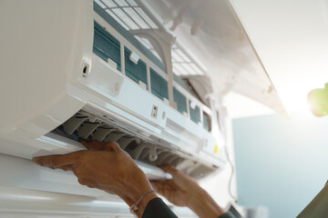 The worker cleans and repairs the air conditioner to ensure it operates properly