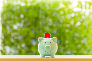 Piggy bank and home model put on the top  with grow value with working capital management in the public park, Loan and business investment for real estate concept.