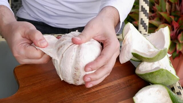 Close up of human hands cleaning pomelo fruit.