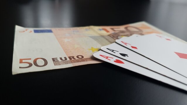 Three aces lying next to the Euro banknote