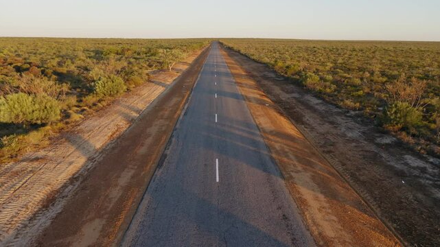 Aerial crane shot of road in the outback at sunset, Western Australia