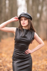 Portrait of a young beautiful brown-eyed long-haired girl in a black dress in nature.