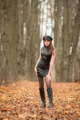 Portrait of a young beautiful brown-eyed long-haired girl in a black dress in nature.