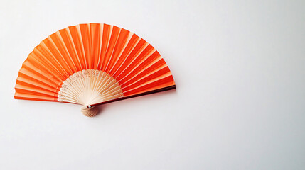 orange folding hand fan on white background  - asian culture and decoration - summer and warm weather symbol -  minimalist design  - stock photo