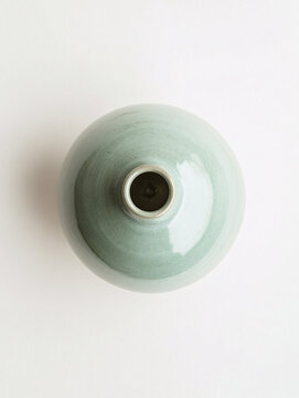 green ceramic vase on white background minimalist still life photo