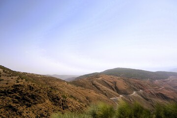 Scenic view of winding road through mountainous terrain in the countryside under a clear sky